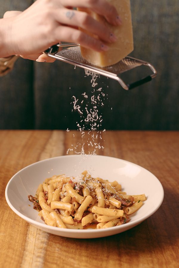 The chef at the Treasury Hotel is grating cheese onto spaghetti