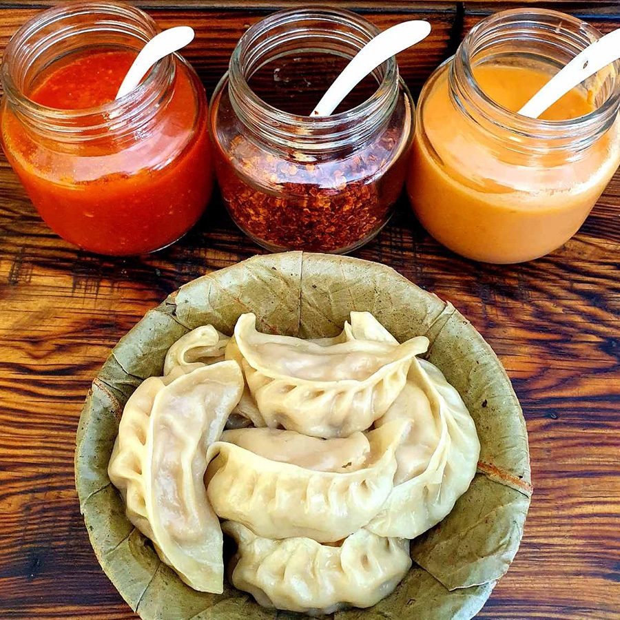 A plate of momos and three sauces at Aambo Momo