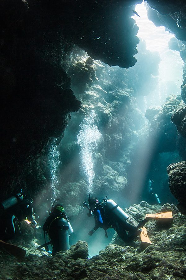 A Scuba diver is diving in a clear under water cave