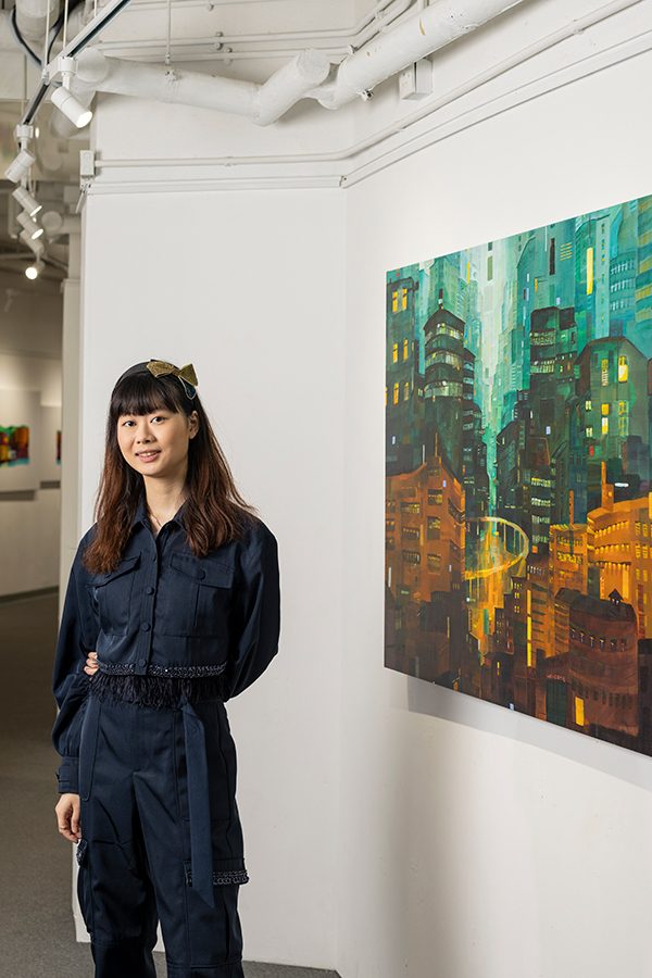 Elaine Chiu with black suit standing near an artwork