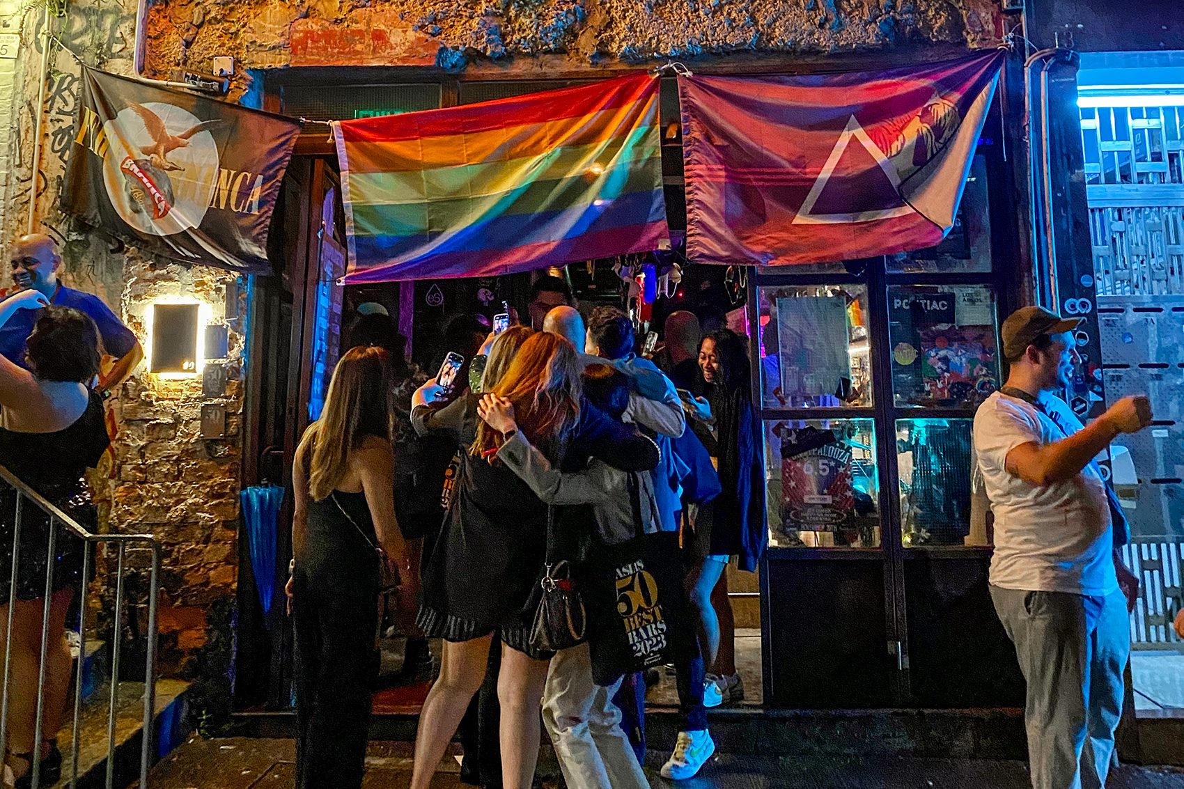 People standing outside Hong Kong's The Pontiac with pride flags hung up