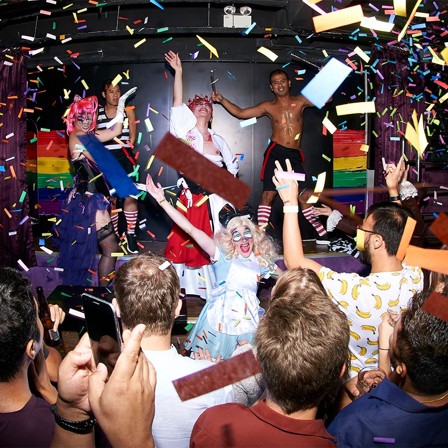 Performers on stage at Cafe Queen by FLM with rainbow-coloured confetti in the air