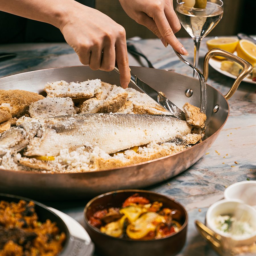 At the Upper House, a person is cutting fish into pieces.