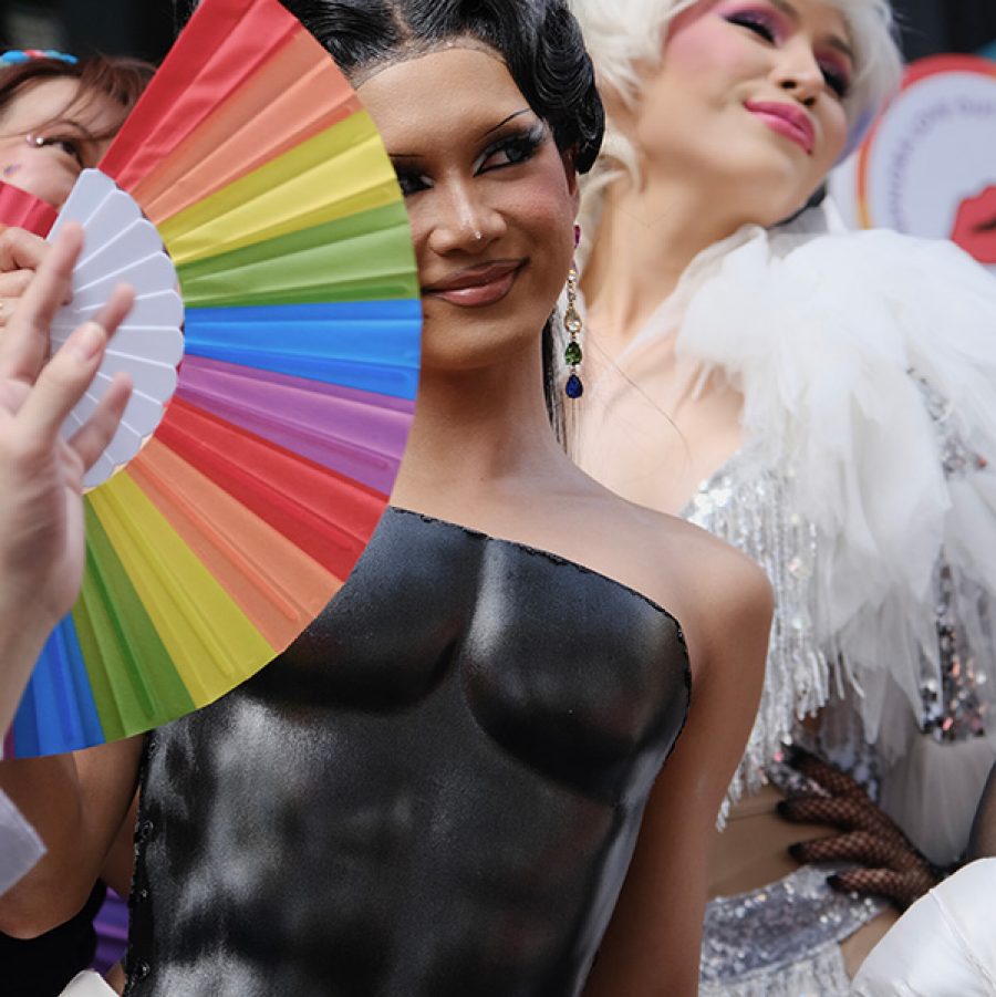 A person in drag make up and black suit at a pride parade in Bangkok, Thailand