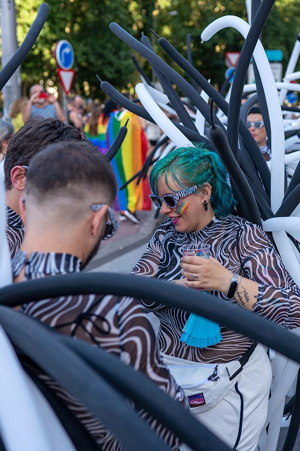 A person wearing black and white balloons at a pride parade in Madrid, Spain