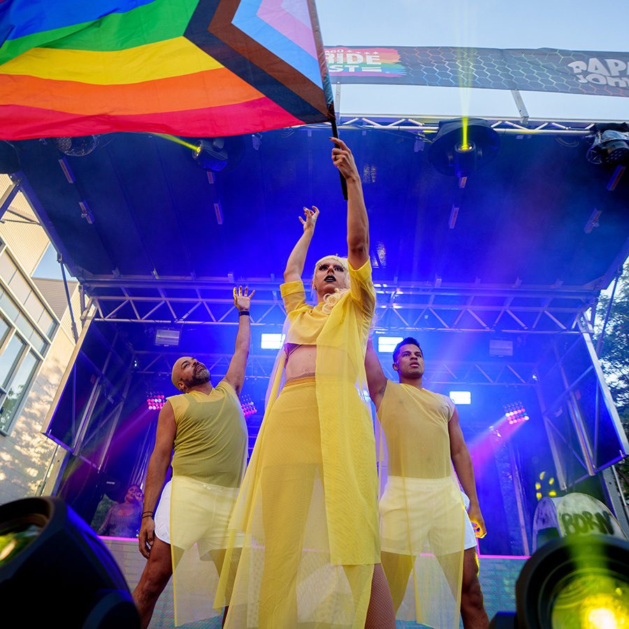 LGBTQ+ Performer holds up rainbow flag at a pride parade in Chicago, Illinois