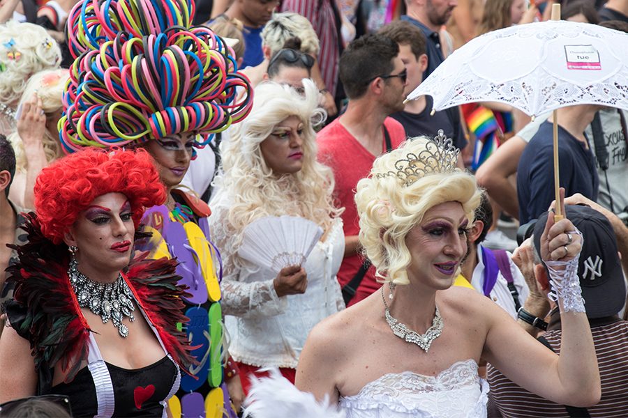 LGBT community in drag costumes at a ride parade in Paris, France