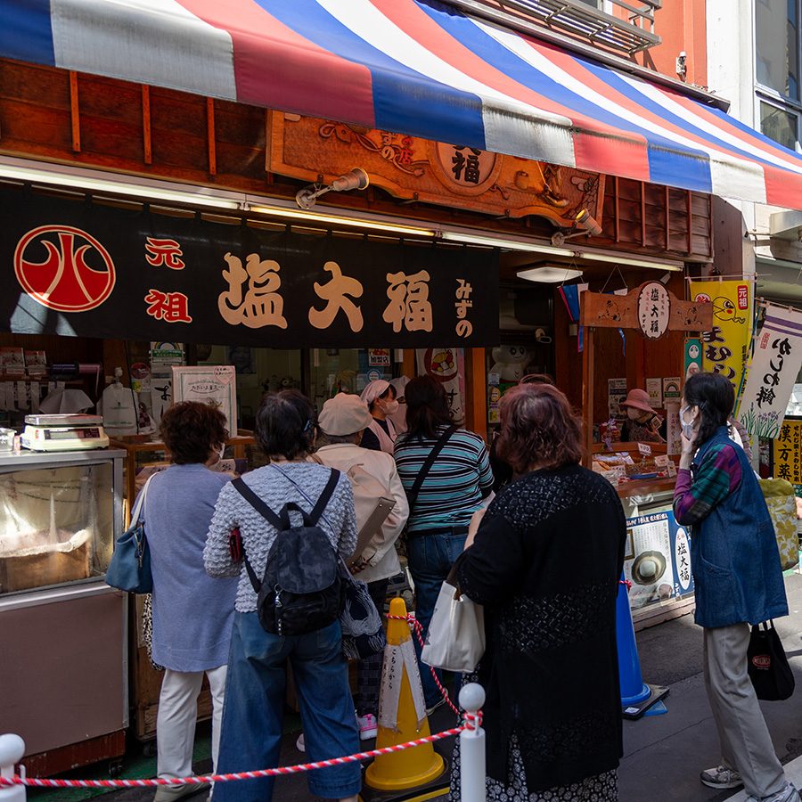 People are lining up for Shio Daifuku Shop at Sugamo Jizo dori shopping Street