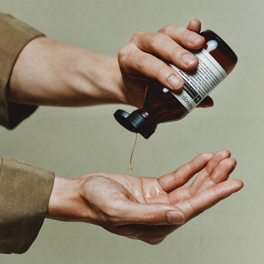 a person pouring Aesop's immaculate facial tonic into a hand