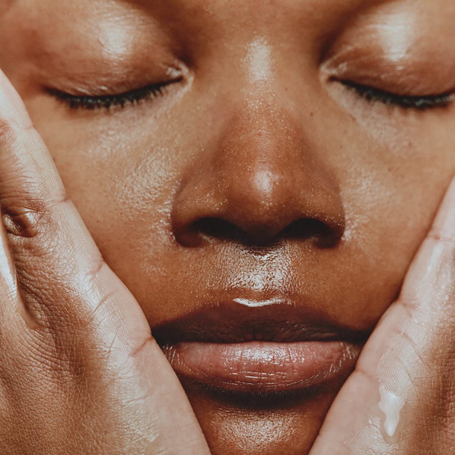 a woman doing her skincare routine applies Aesop's immaculate facial tonic onto her face