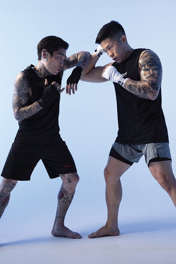 two men sparring and fighting wearing Pure fitness t-shirts