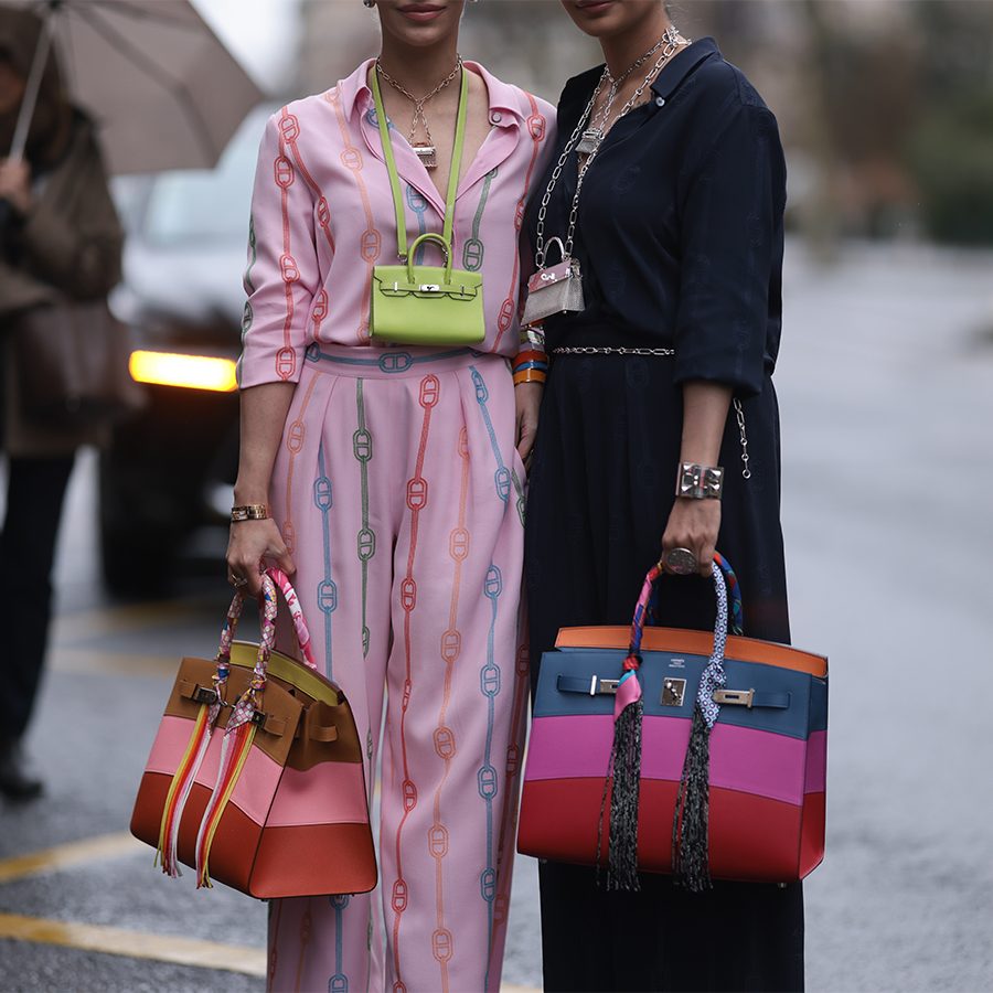 Two women holding Hermès Birkin bags at Paris Fashion Week 2024