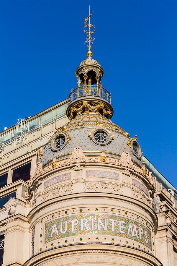 A closeup photo of the dome of Printemps during the day
