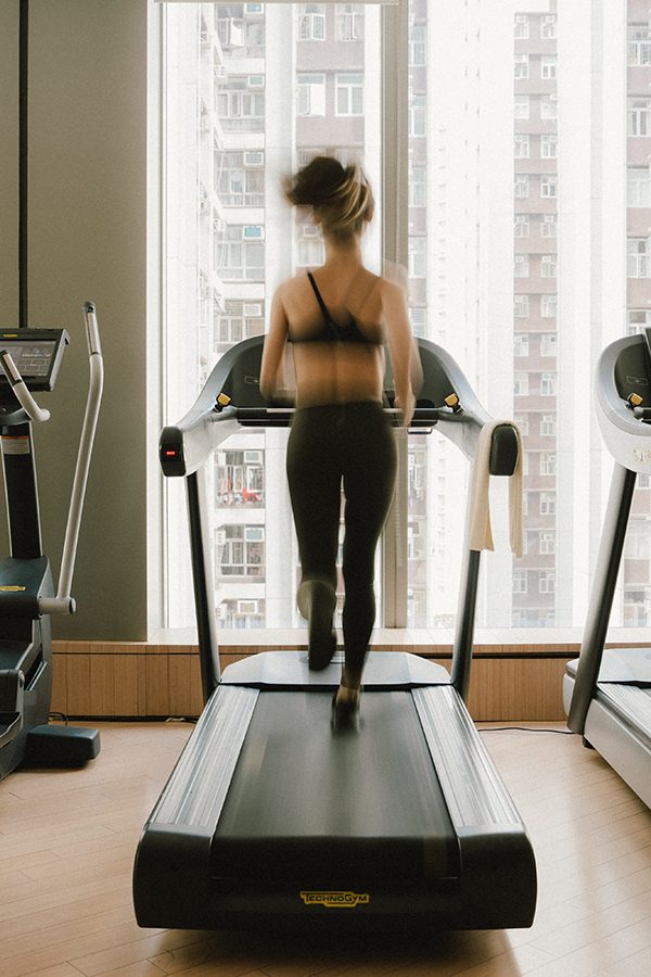 A woman is running in a gym room at EAST Hong Kong