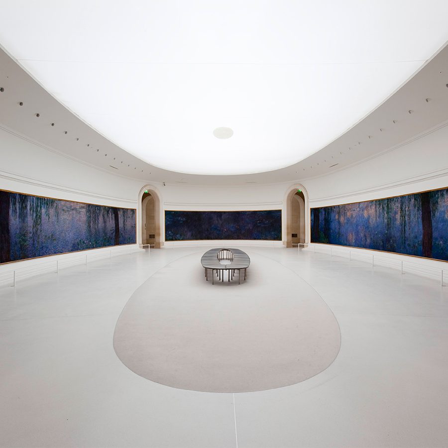 A wide angle photo of a white room inside Musée de l'Orangerie in Paris, France