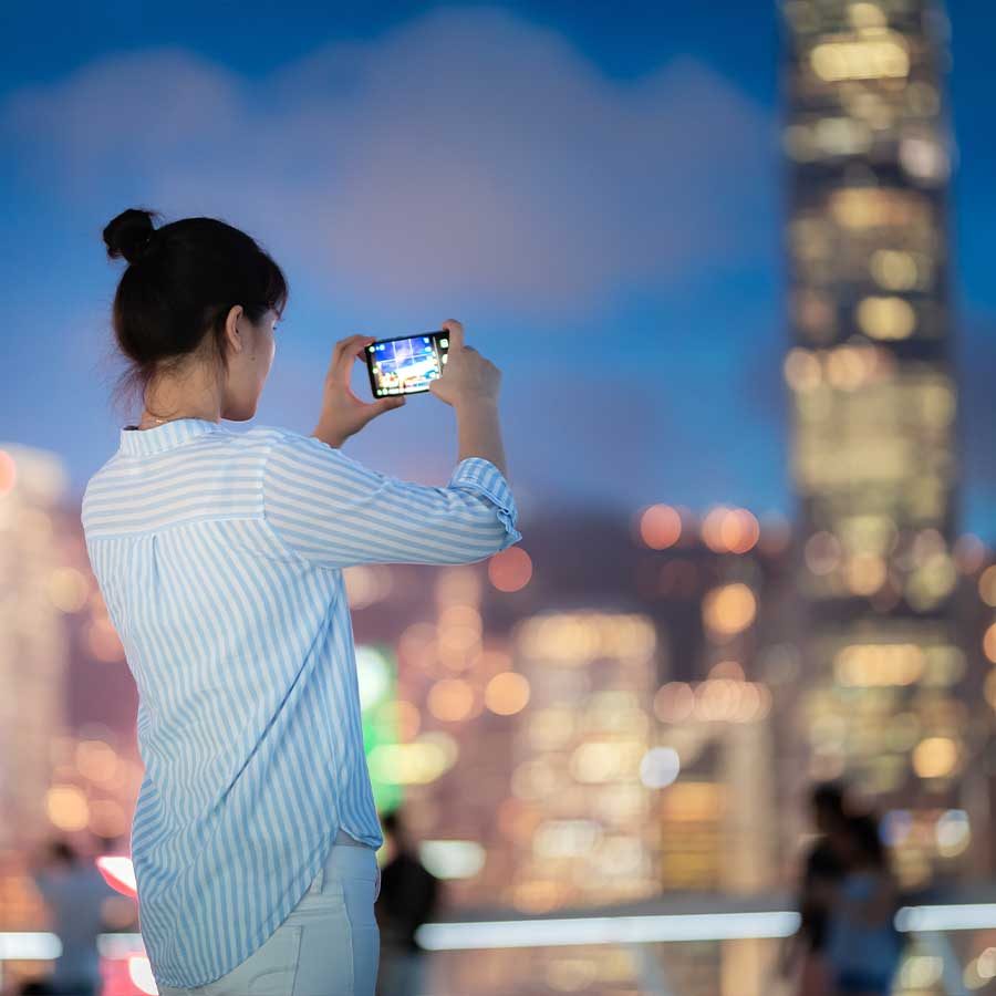 Person taking picture of Hong Kong's night view