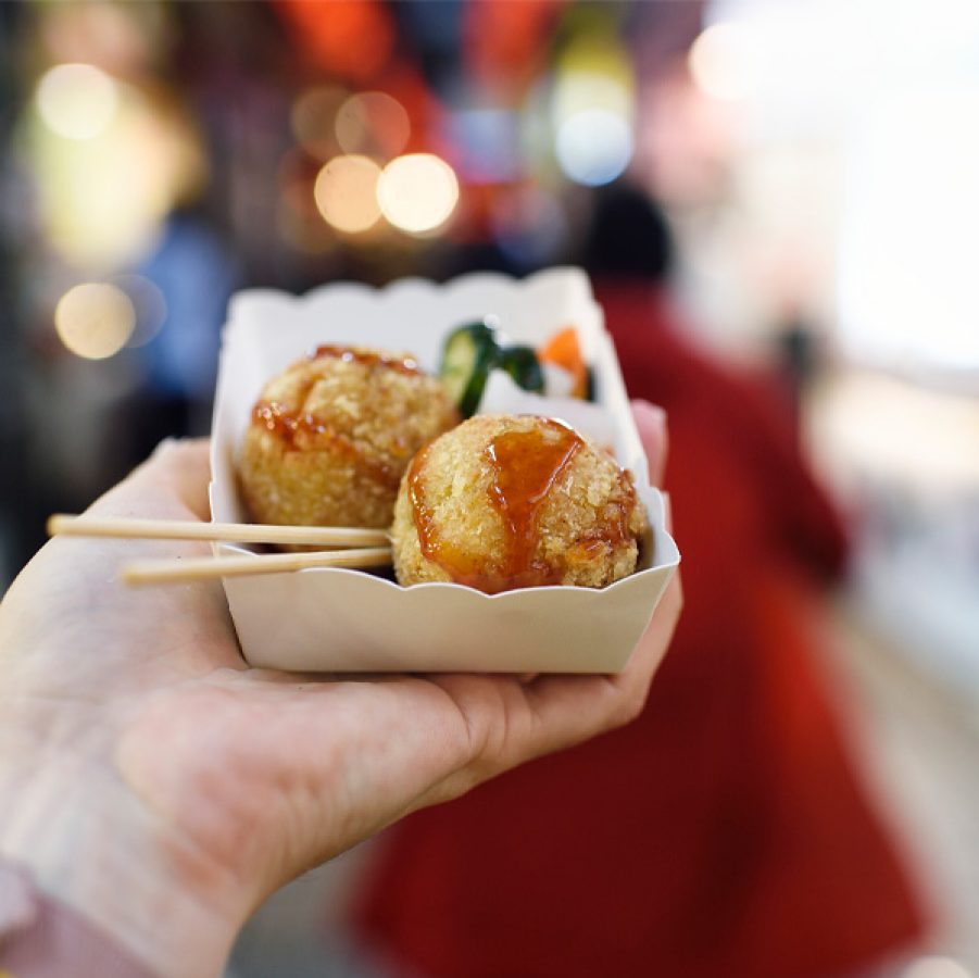 Hand holding street food in dish