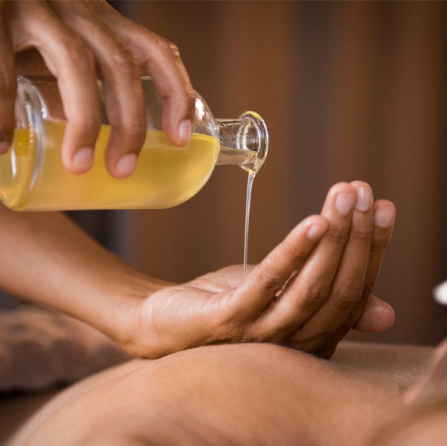 Oil being poured on hands for massage