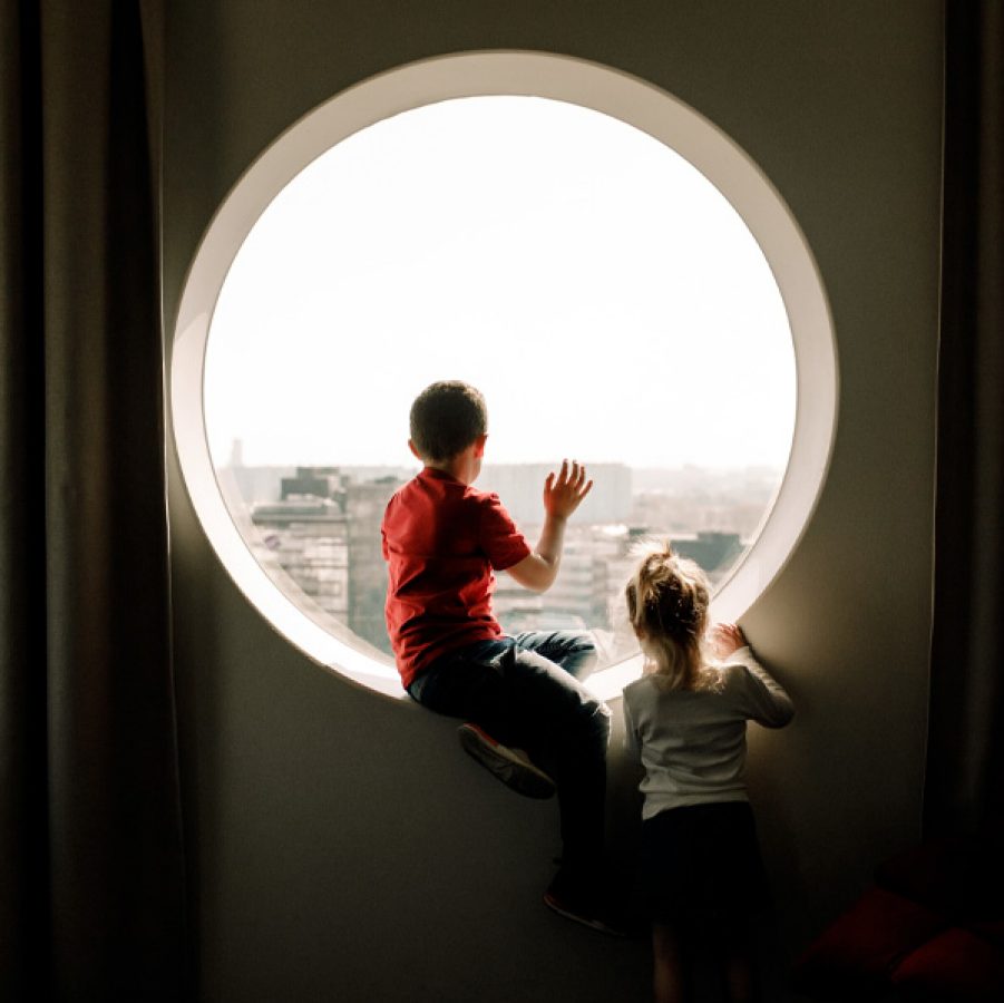 Two children sitting by the window