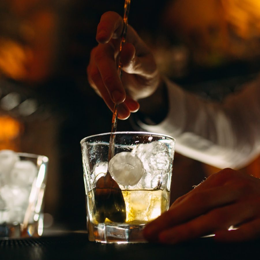 Bartender stirring drink at a bar