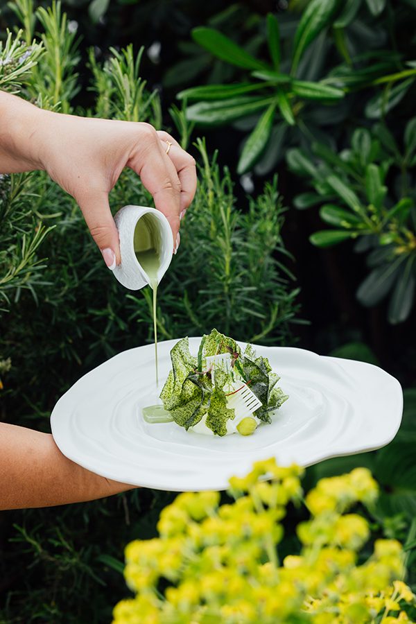 Dish being plated in gardens of The Peninsula Paris 