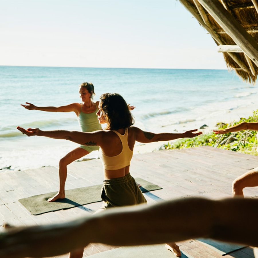People doing yoga on the beach