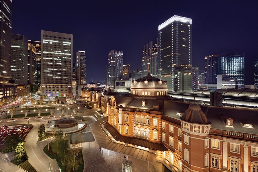An exterior view of Shangri-La Tokyo hotel at night with the city's skylight in the background