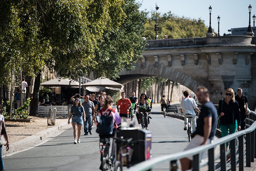 People walking and cycling down a road in Paris