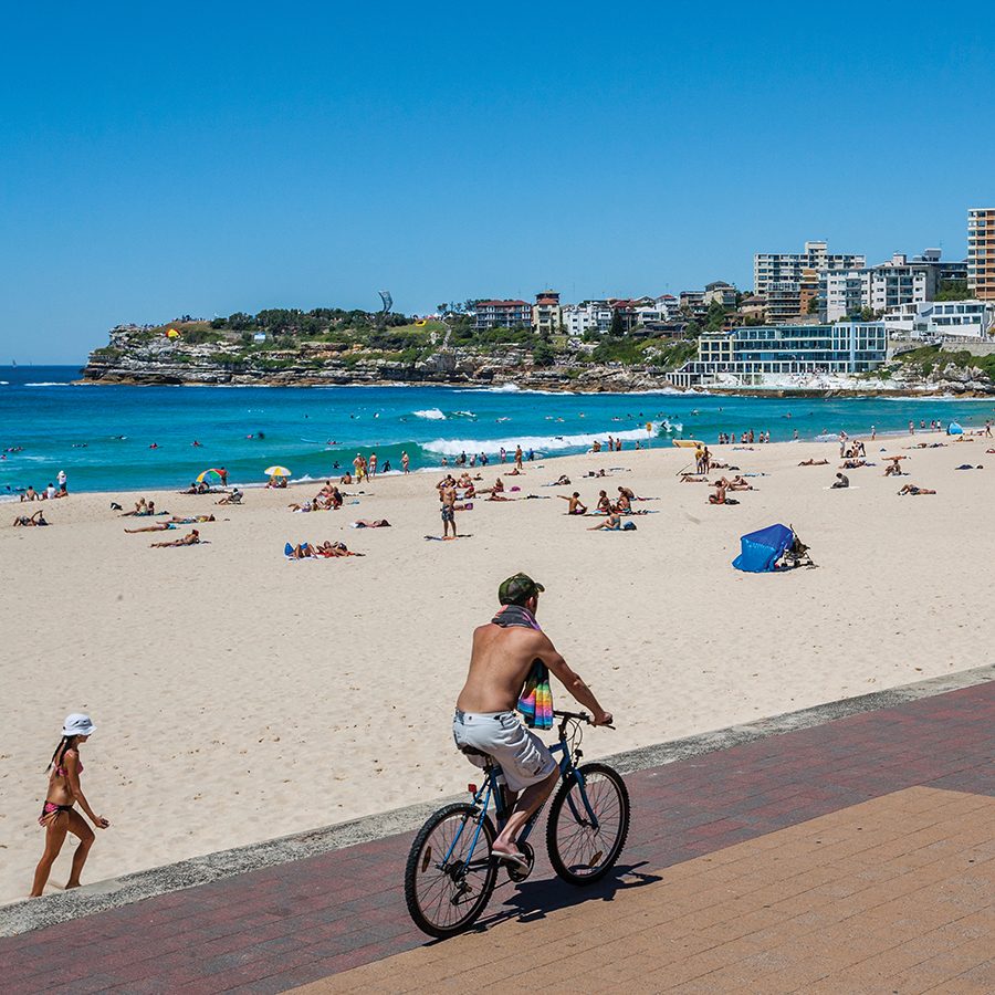 A man biking by Bondi Beach in Sydney