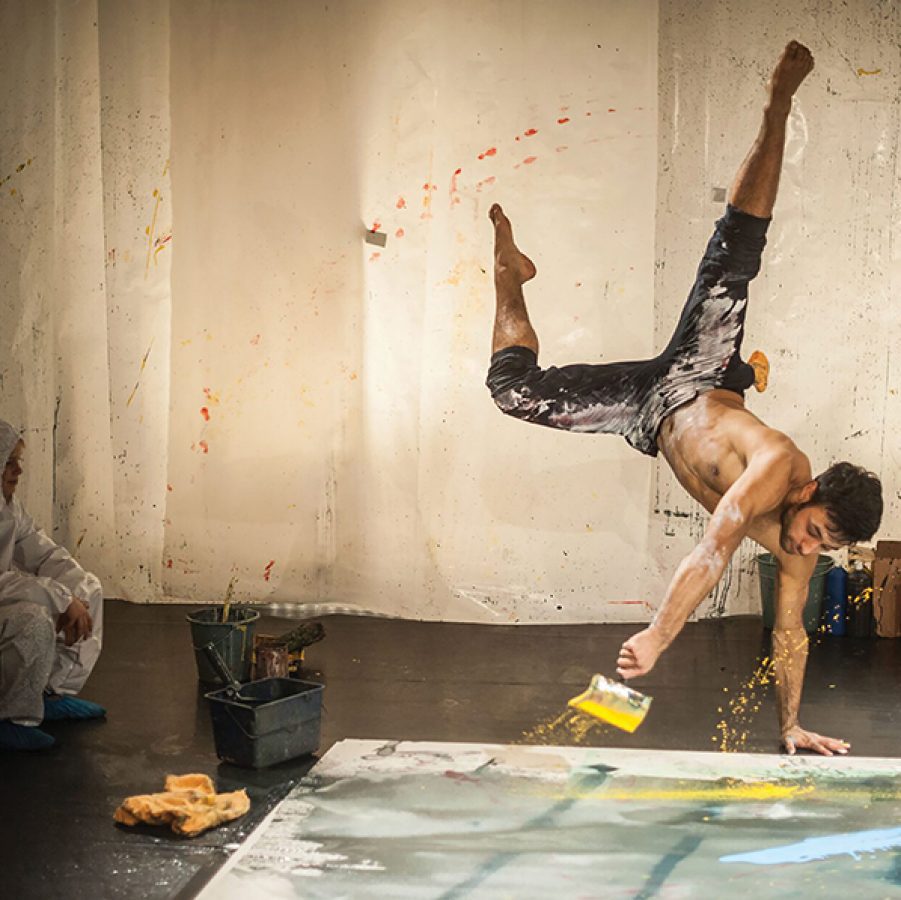 man standing on his hands and painting