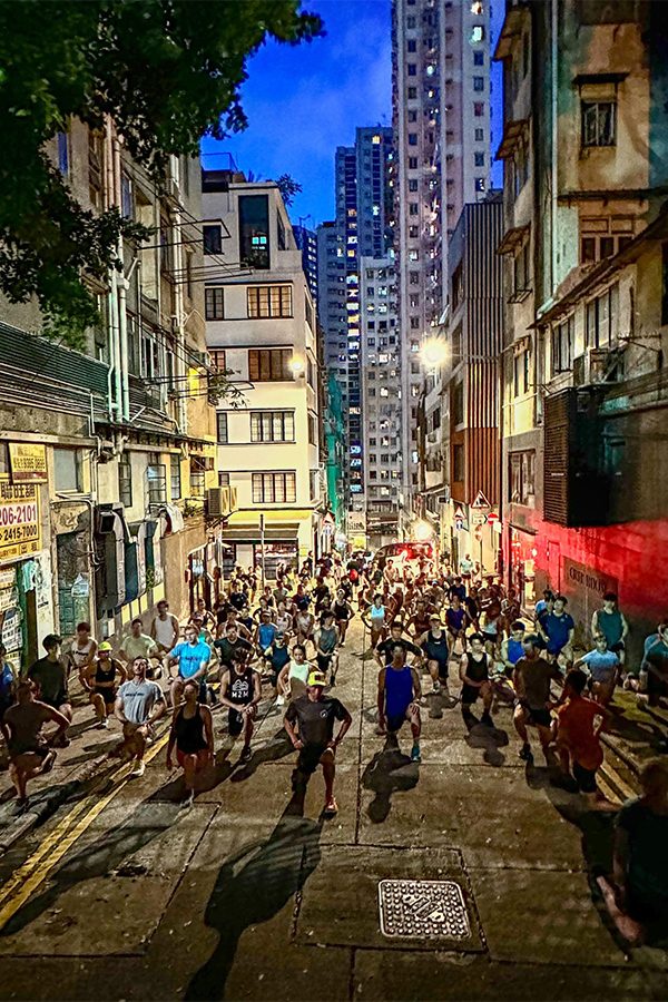 A group of people warming up in the street for a run in the evening at Sheung Wan, Hong Kong