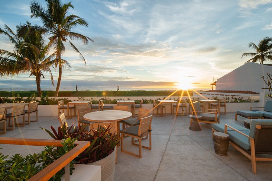 A view of the rooftop bar at Charlie's in Sri Lanka with clear skies and the sunset in the background