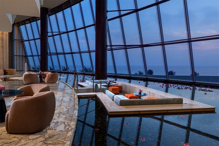 A wide view of the interiors and plush sofa seats and lounge area by the pool at Ratnadipa, Colombo, Sri Lanka
