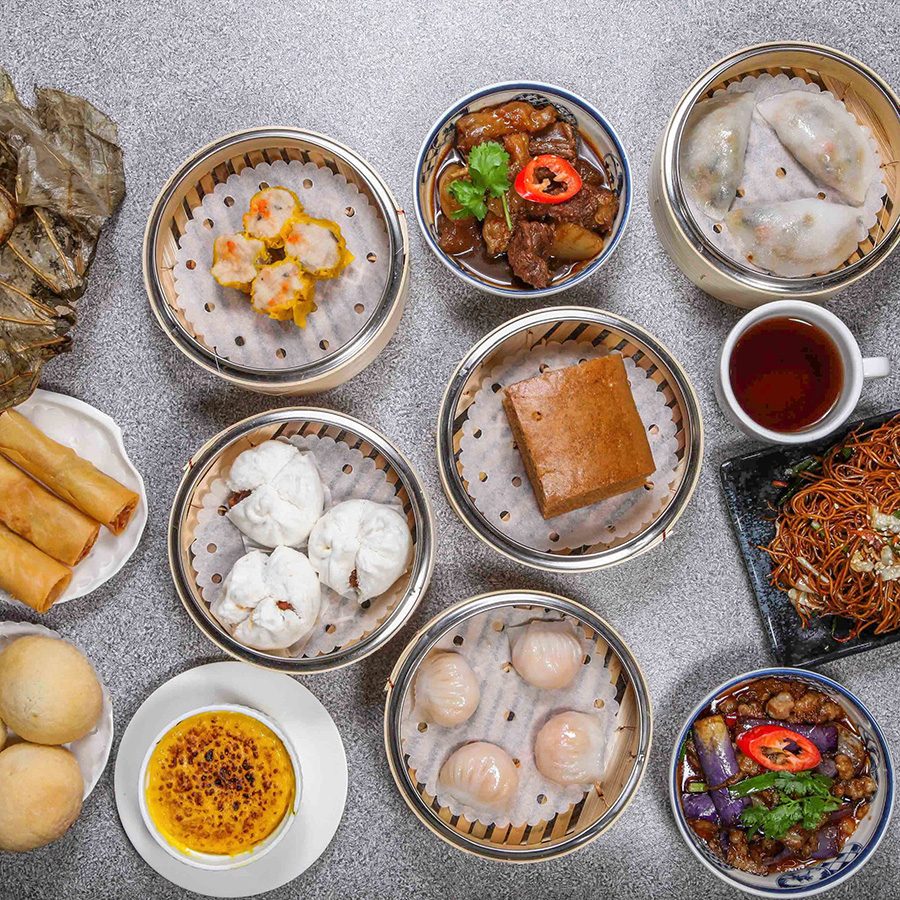 An aerial view of an assortment of dim sum dishes on plates and in steamers 