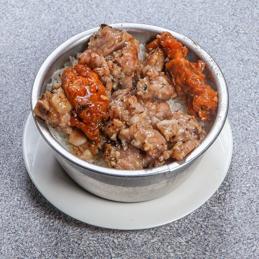 A bowl of rice topped with meat and sauce