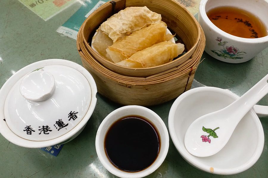 A cluster of bowls and cups containing food and drink on a table
