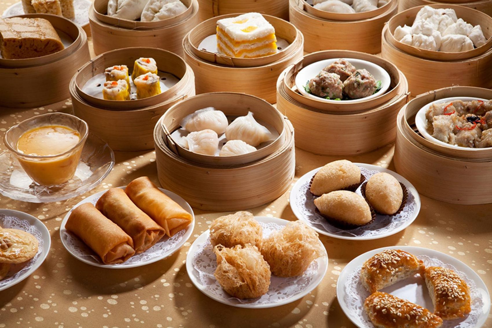 An assortment of dim sum dishes on plates and in steamer baskets 