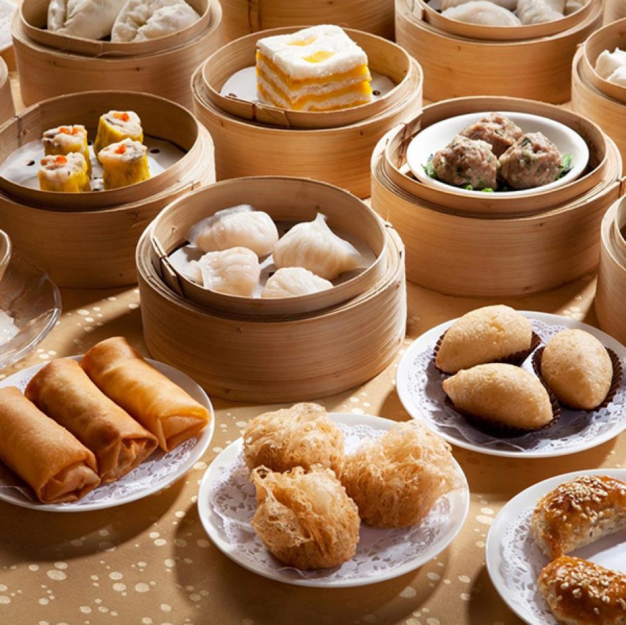 An assortment of dim sum dishes on plates and in steamer baskets 