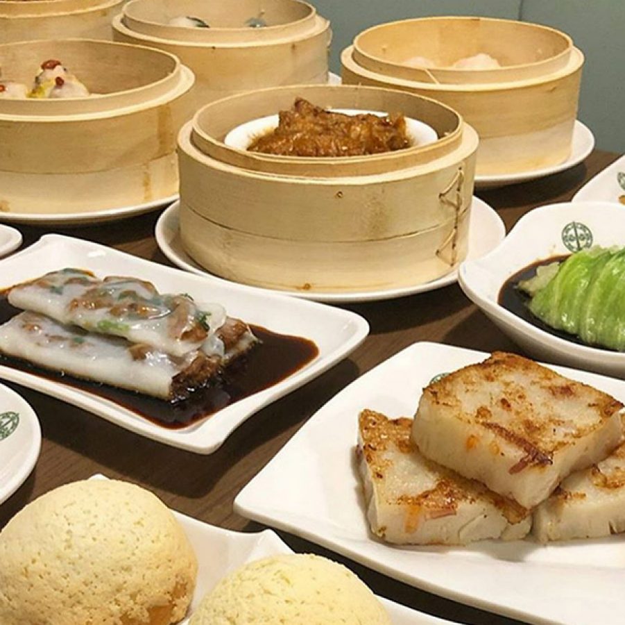 A table of assorted dim sum dishes on plates and in bamboo steamers 