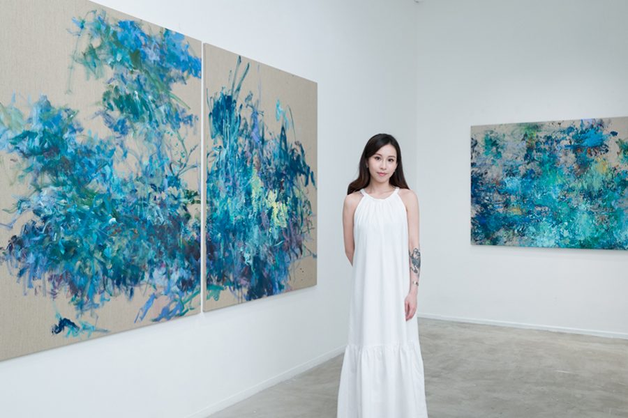 Rosalyn Ng posing in front of her art work Scenery of My Mind at Soluna Fine Art gallery