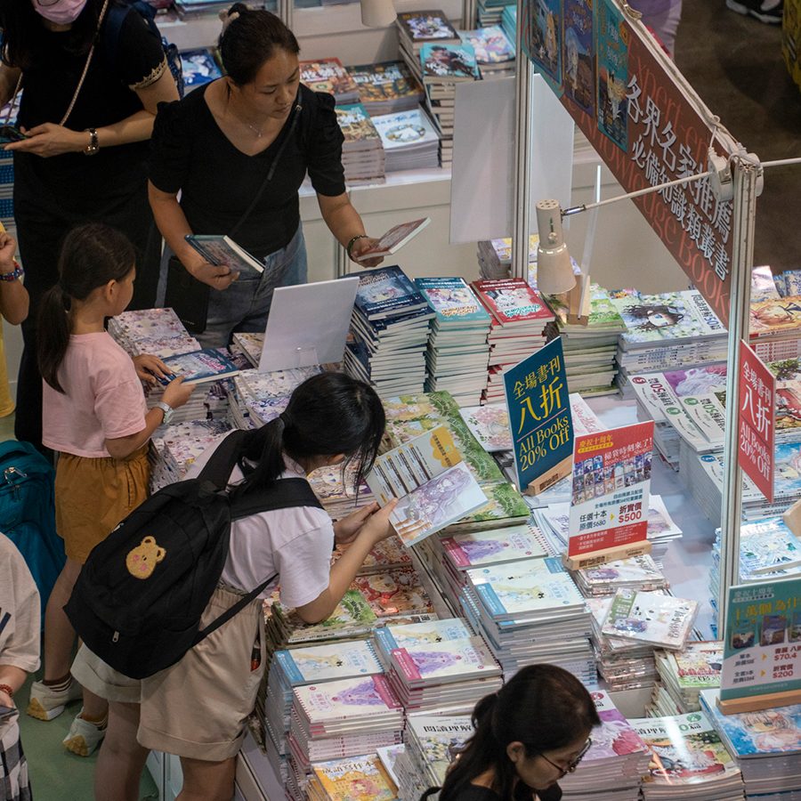 People are reading books at the book fair booth.