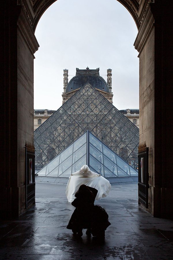 A photographer in front of the Grand Louvre.