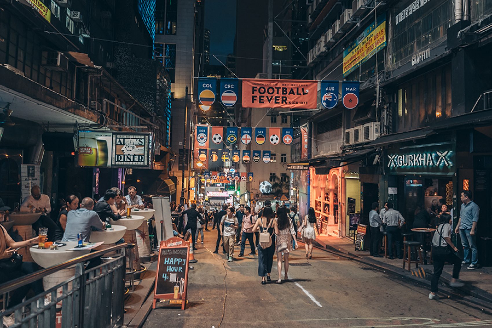 There are quite a few people walking in Lan Kwai Fong at night.