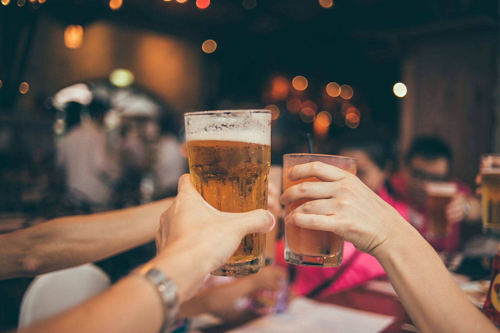 People toast with beer at dinner.