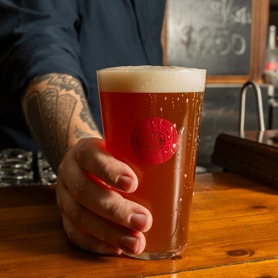 The bartender puts down a beer.