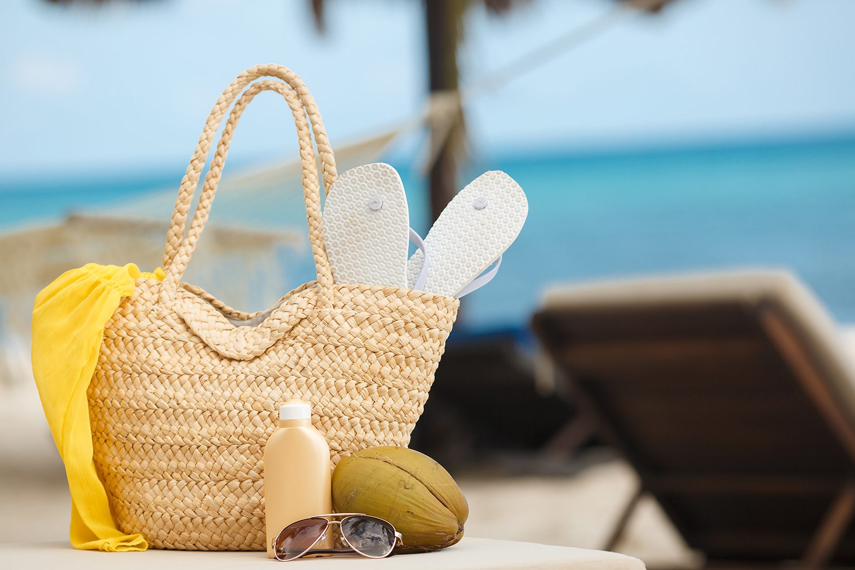 Vintage summer wicker and straw beachbag on the beach.