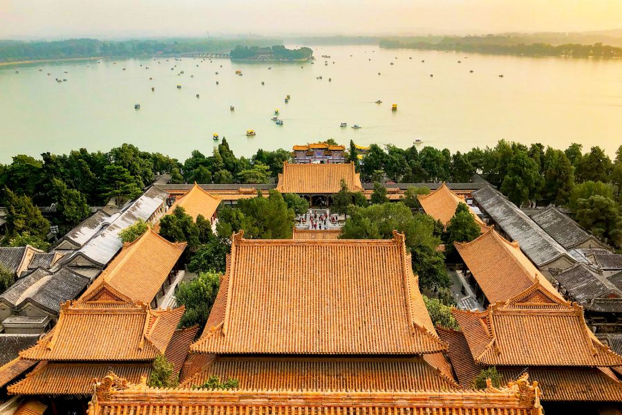 An aerial view of the Summer Palace in Beijing at sunset, showcasing the tile roofs