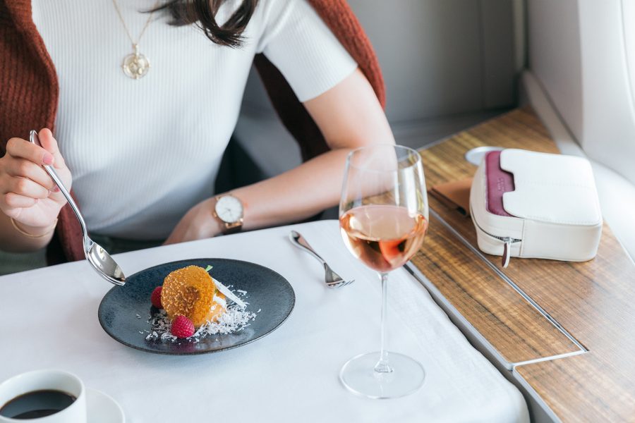 Woman eating and drinking rose wine