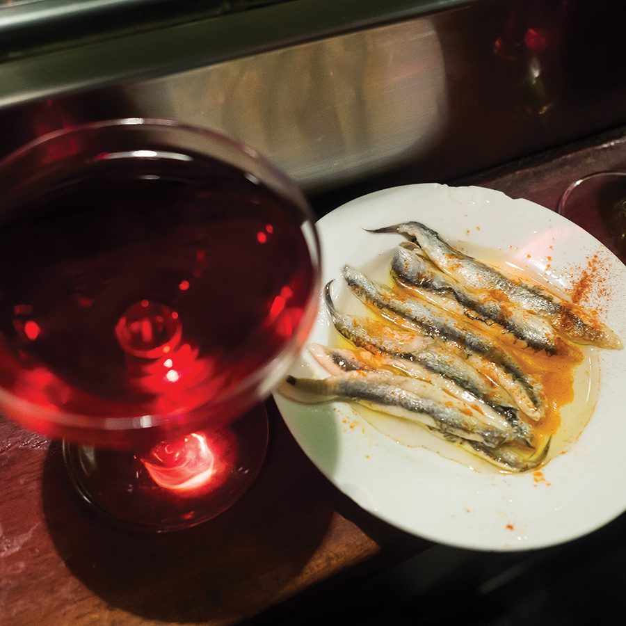 A dish of Spanish food and a glass of drink