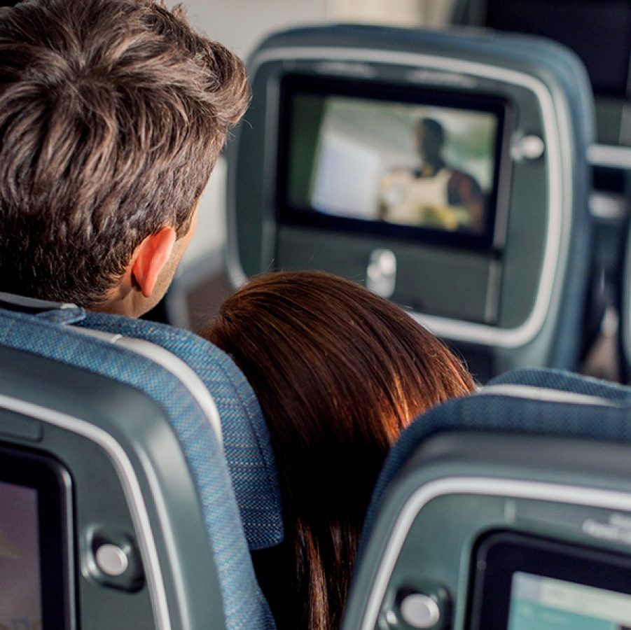 A couple watching TV on the plane